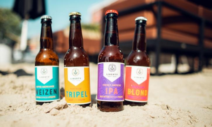 Bieren van Liberty Craft Beer Vier flesjes bier van Liberty Craft Beer in het zand gestoken